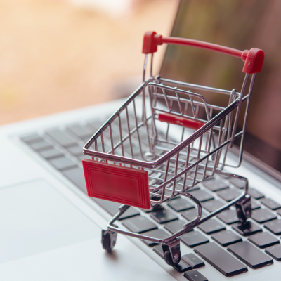 toy shopping cart on top of laptop keyboard